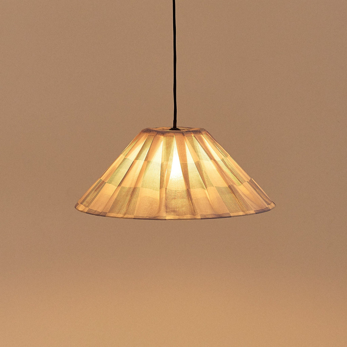 Nobodinoz Ava geplooide lampenkap van 50 cm in inktblauw ruit tegen een lichte achtergrond, vanuit een andere hoek.