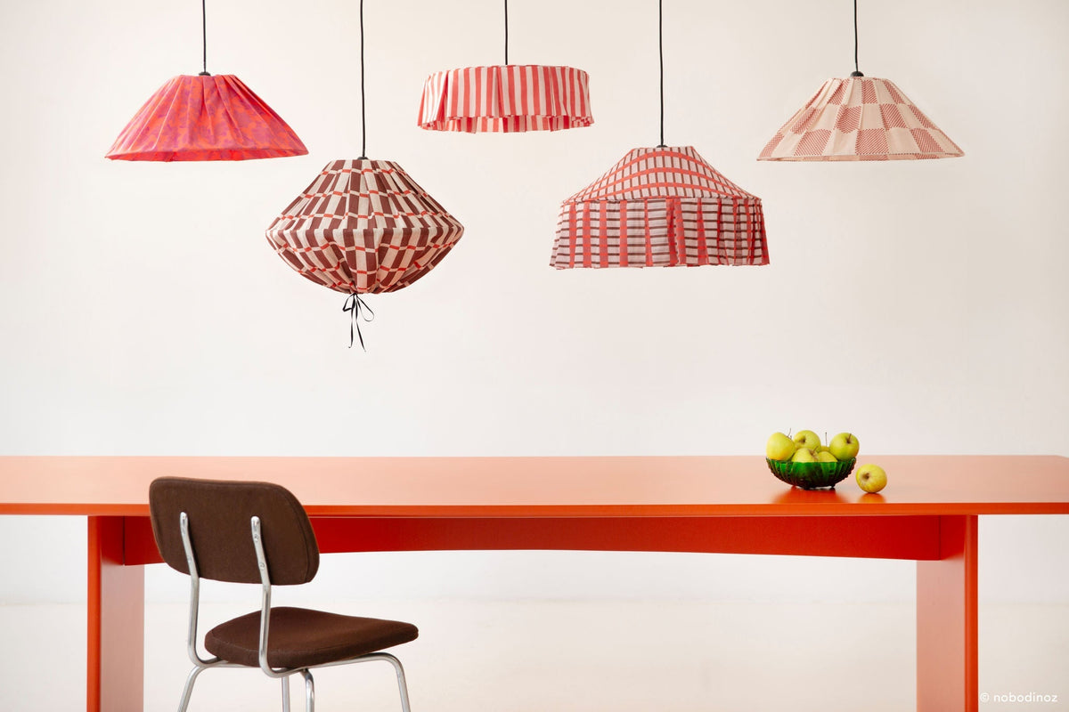Nobodinoz Ava geplooide lampenkap van 50 cm in gebrand rood ruit samen met andere lampenkappen uit de Nobodinoz-collectie.