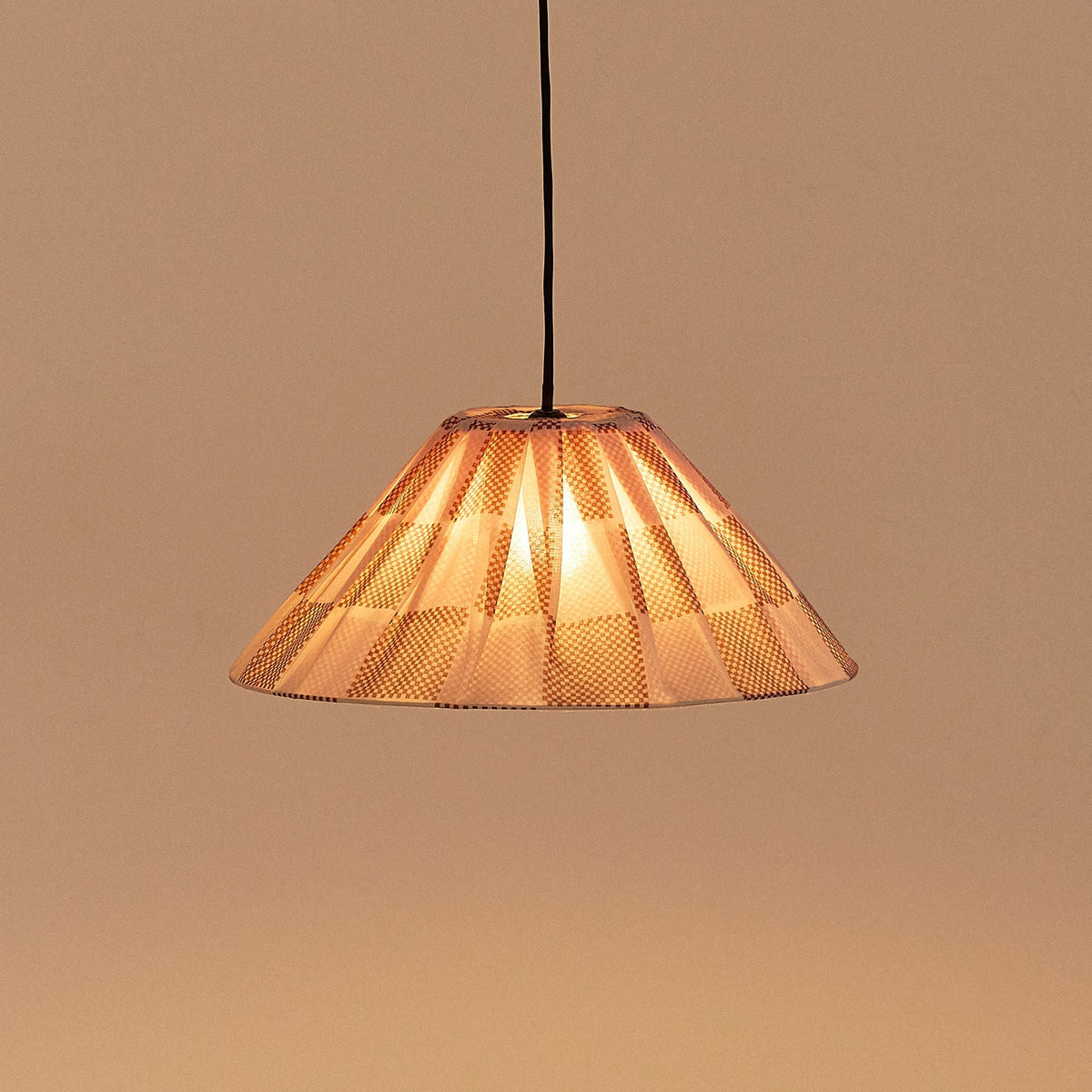 Nobodinoz Ava geplooide lampenkap van 50 cm in gebrand rood ruit tegen een lichte achtergrond, vanuit een andere hoek.