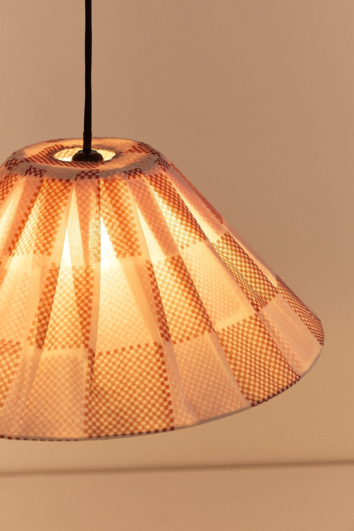 Nobodinoz Ava geplooide lampenkap van 50 cm in gebrand rood ruit als sfeervolle hanglamp in een mediterraan interieur.