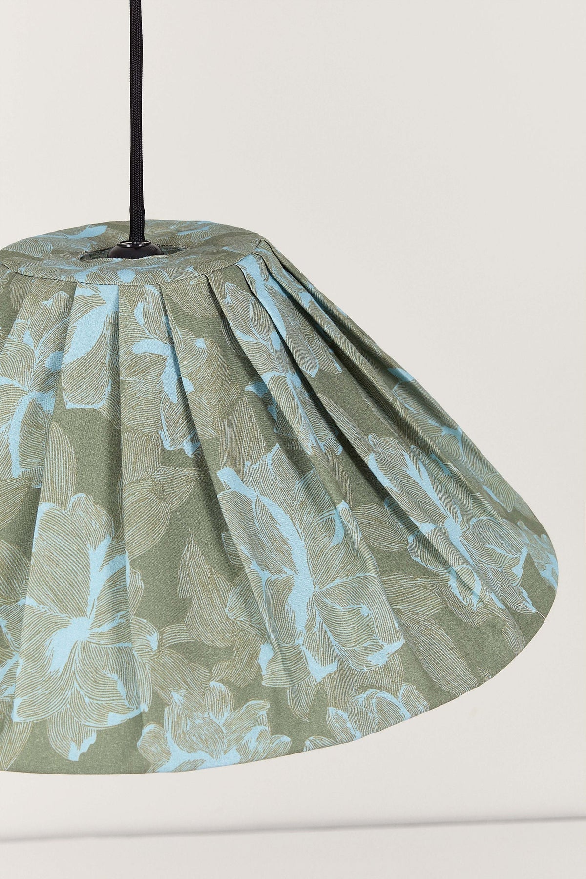 Nobodinoz Ava geplooide lampenkap van 50 cm in groene pioenrozen in een licht, mediterraan ingericht interieur.
