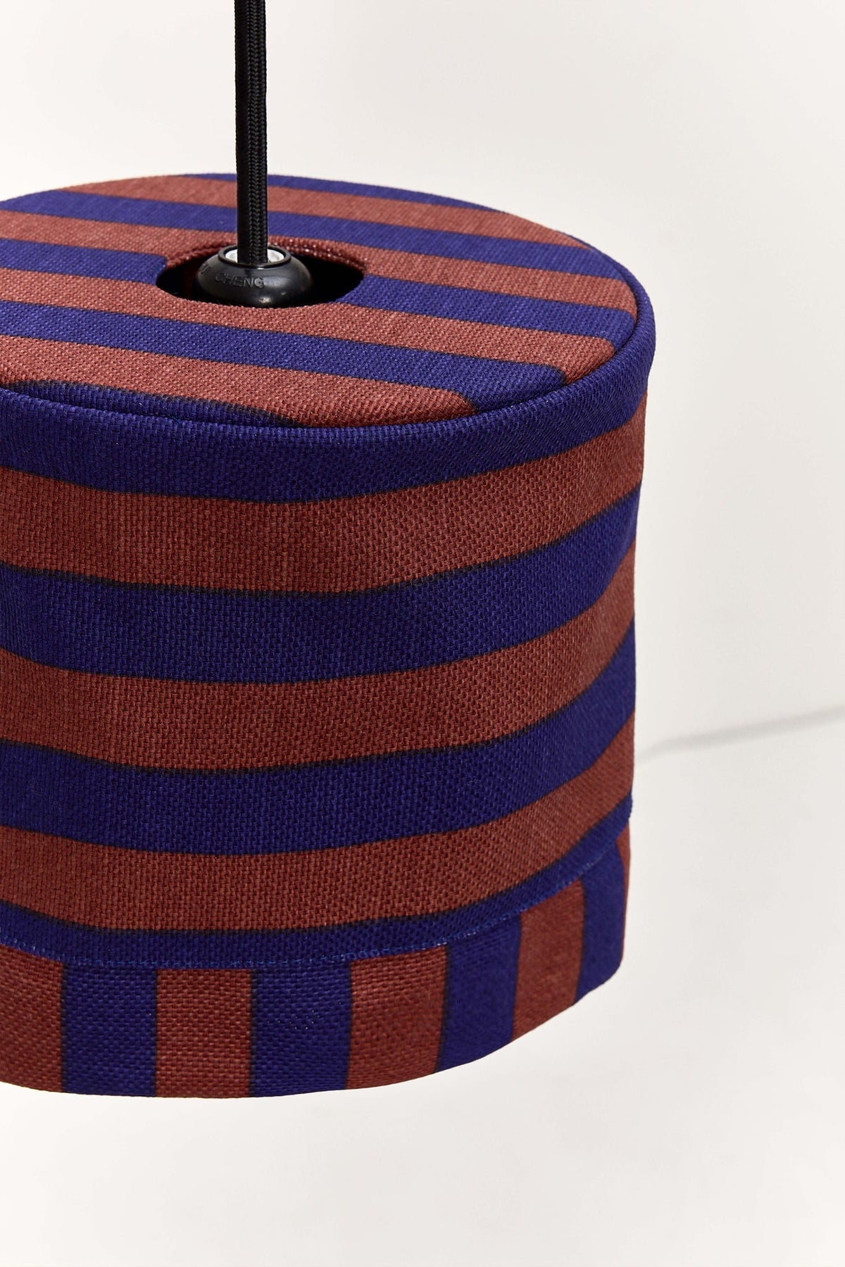 Nobodinoz Linda katoenen lampenkap van 20 cm in kastanje-inkt strepen in een licht, mediterraan ingericht interieur.