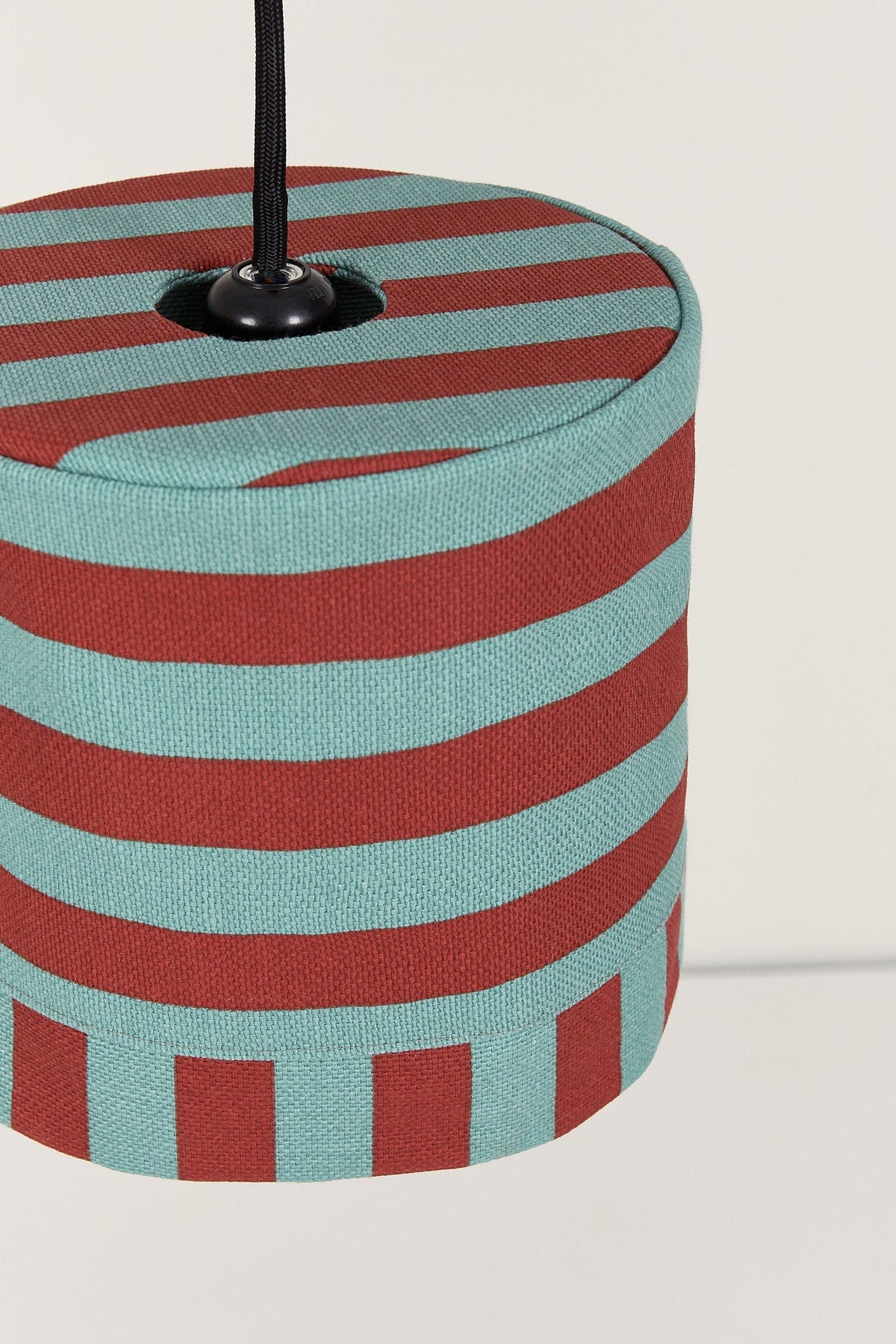 Nobodinoz Linda katoenen lampenkap van 20 cm in rood-petrol strepen in een licht, mediterraan ingericht interieur.
