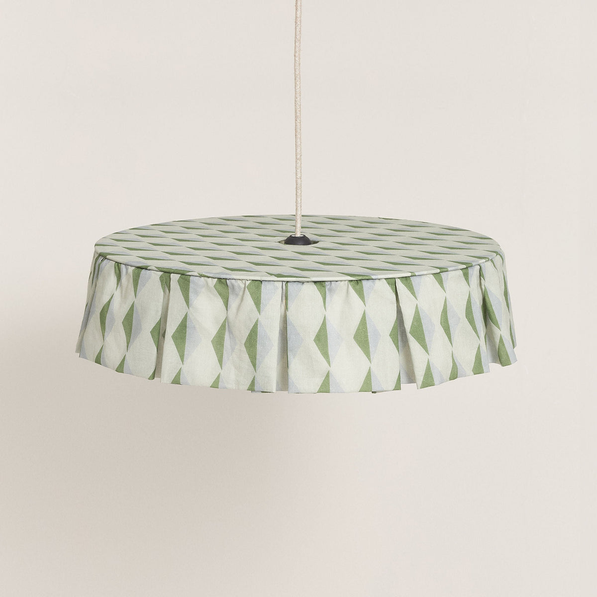 Nobodinoz Vibes katoenen lampenkap van 50 cm in groen-blauw harlekijn tegen een lichte, warme achtergrond.