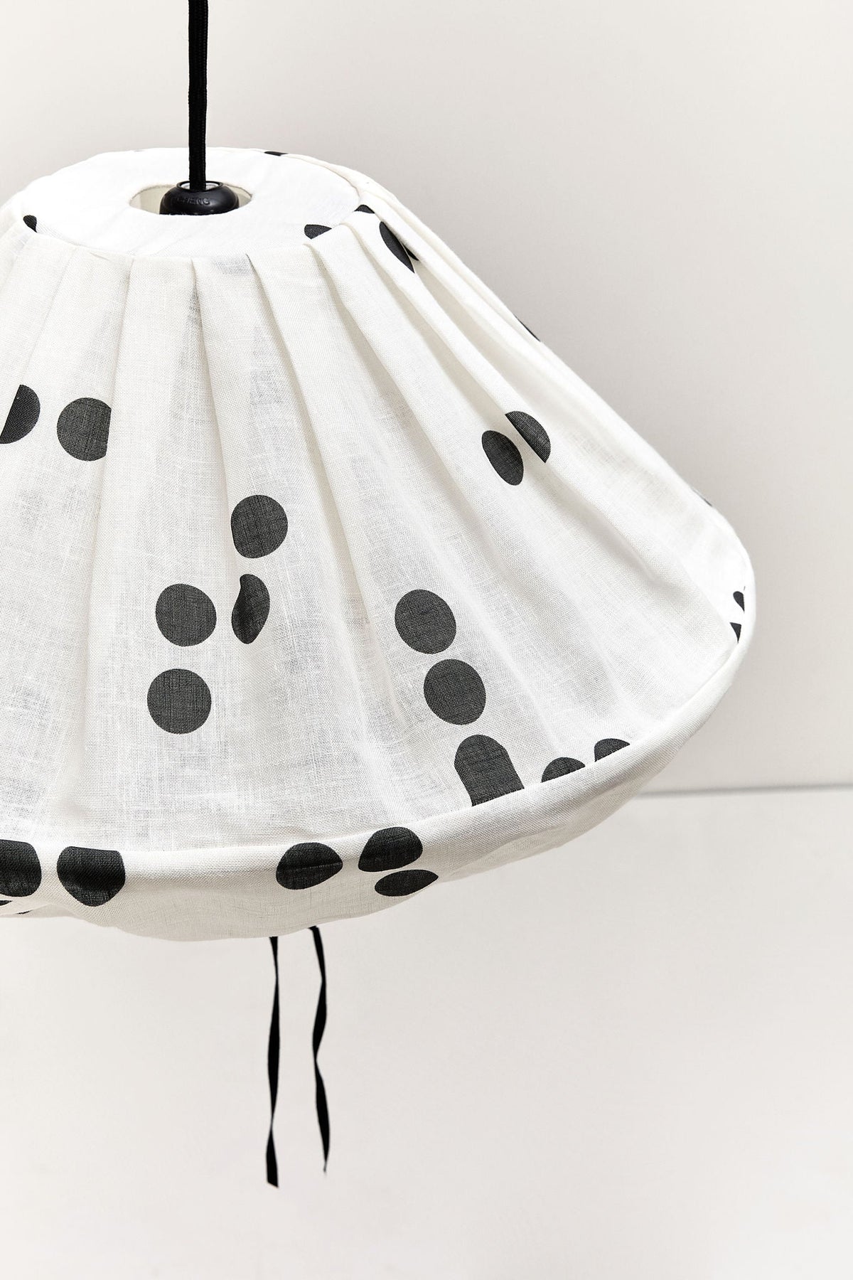 Nobodinoz Yumi linnen lampenkap van 50 cm in zwarte stippen in een licht, mediterraan ingericht interieur.