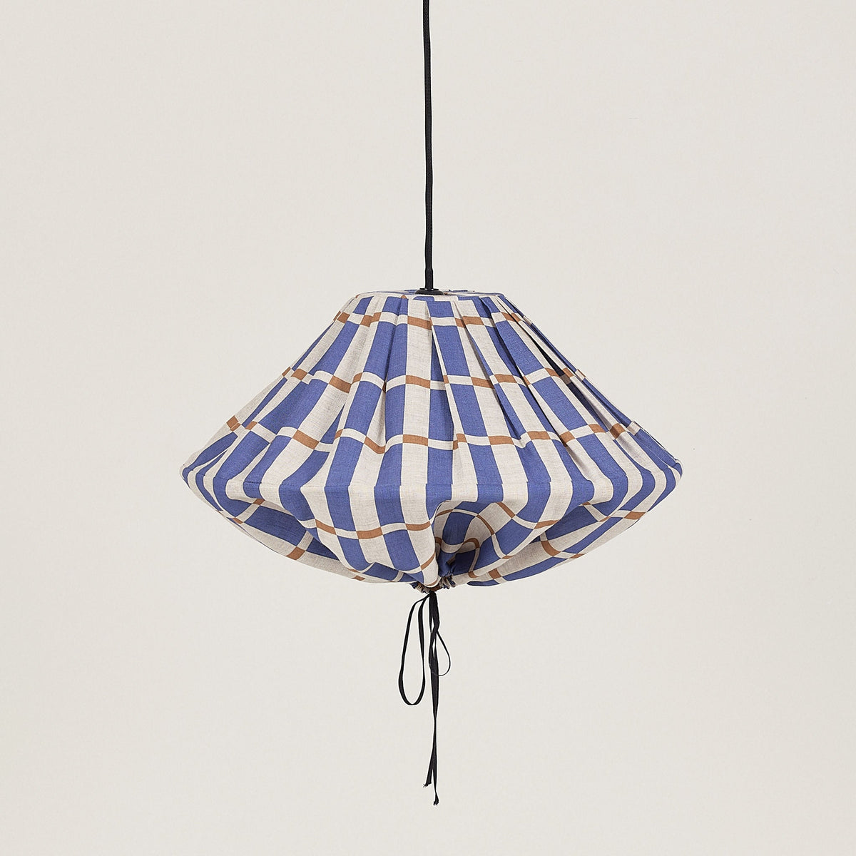 Nobodinoz Yumi linnen lampenkap van 50 cm in blauw-mosterd mozaïek tegen een lichte, warme achtergrond.