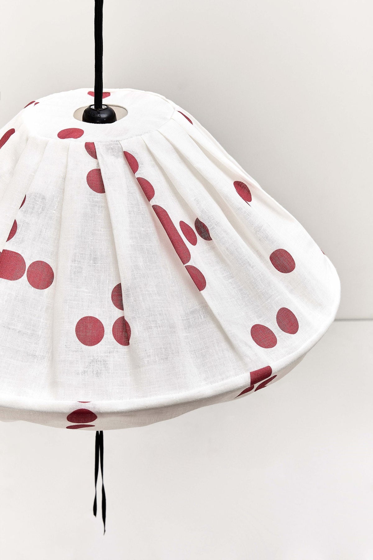 Nobodinoz Yumi linnen lampenkap van 50 cm in rode stippen in een licht, mediterraan ingericht interieur.