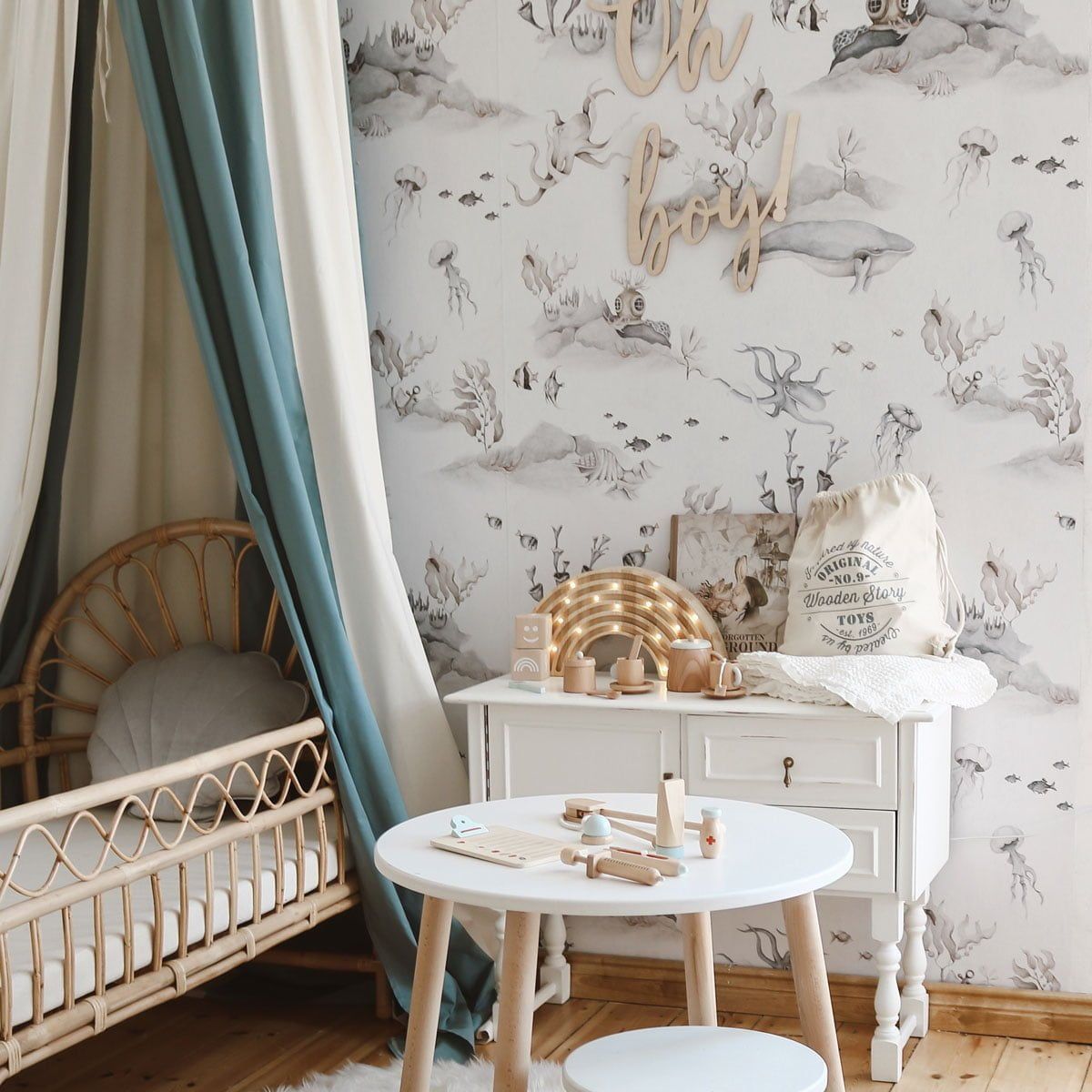 Dekornik Underwater World White Behang — Een rustig behang met een onderwaterwereld vol visjes en zeewezens op een witte achtergrond, perfect voor een serene, maritieme kinderkamer. Sfeerbeeld van het behang in een ingerichte kinderkamer.